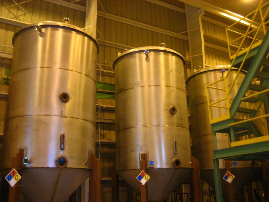 Tall stainless steel tanks inside a biodiesel plant