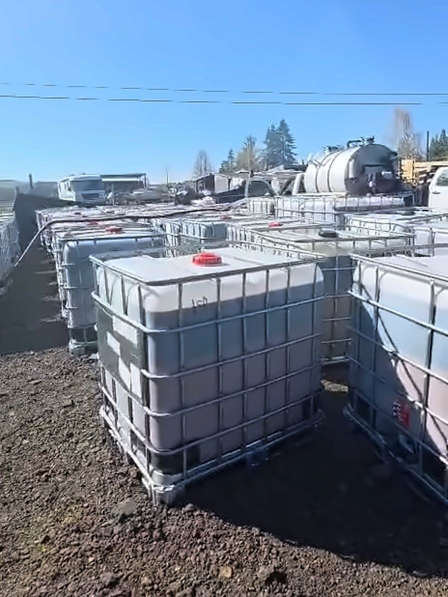 IBC totes lined up on a gravel yard